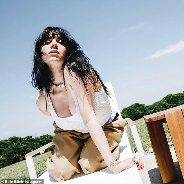 Billie Eilish makes the rare move of showing off her chest in a low-cut tank top for Gucci... after admitting she has had body insecurities all her life